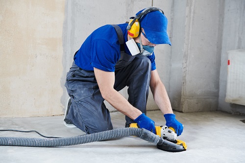 Worker smoothing concrete floor